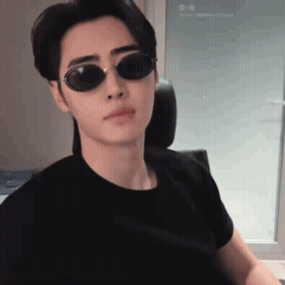 Young Man In Sunglasses And Black T-Shirt Sitting In Chair GIF