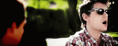 Young Man In Sunglasses And Plaid Shirt Talking To Another GIF