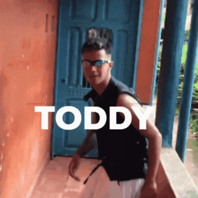 Young Man In Sunglasses By Blue Door With Toddy GIF