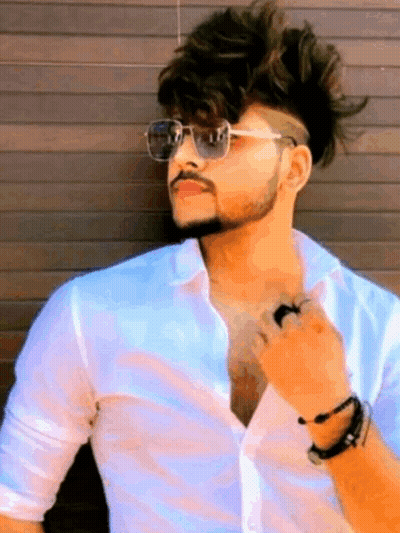 Young Man In Sunglasses Leaning Against Wooden Wall GIF
