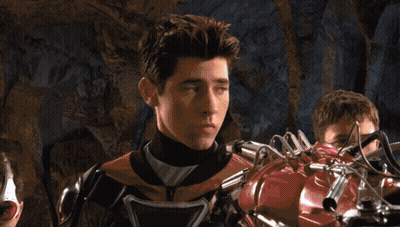 Young Man In Superhero Costume Next To Robotic Arm GIF