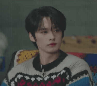 Young Man In Sweater Smiling On Couch GIF