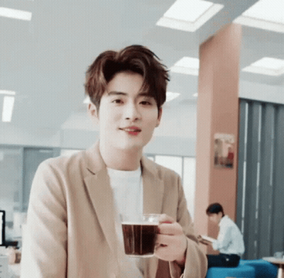 Young Man In Tan Jacket Holding Coffee GIF