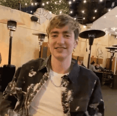 Young Man In Tie Dye Jacket And Chain GIF