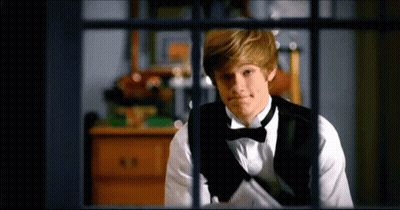 Young Man In Tuxedo Looking Out Window GIF