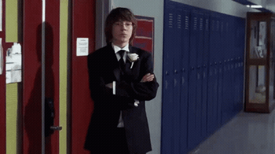 Young Man In Tuxedo Next To Blue Lockers GIF