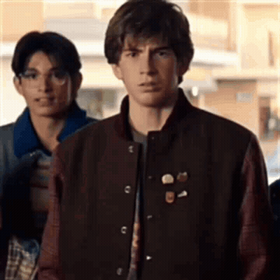Young Man In Varsity Jacket Standing In Line GIF