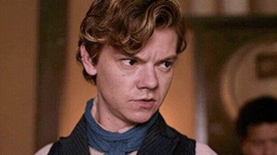 Young Man In Vest And Scarf Making Serious Face GIF