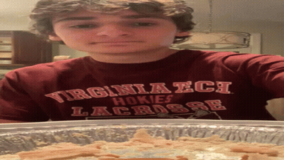Young Man In Virginia Tech Shirt Standing By Pan Of Food GIF
