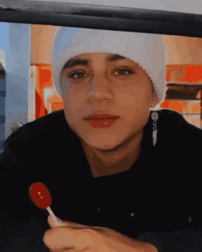 Young Man In White Beanie Holding Red Lollipop GIF