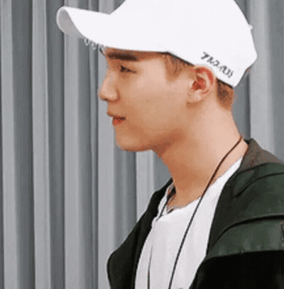 Young Man In White Cap And Green Jacket GIF