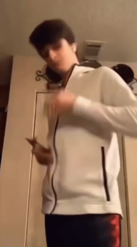 Young Man In White Jacket Holding Cell Phone GIF