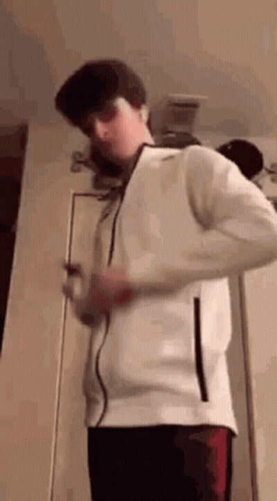 Young Man In White Jacket Holding Cell Phone GIF