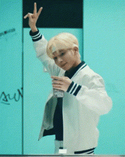 Young Man In White Jacket Making Peace Sign And Holding Water GIF