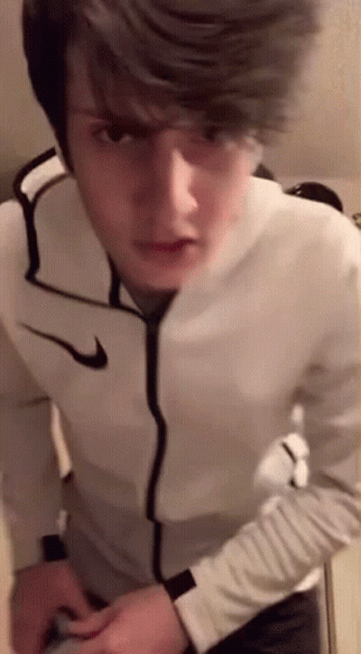 Young Man In White Nike Jacket Standing In Front Of Mirror GIF