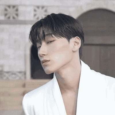 Young Man In White Robe Looking At Camera GIF