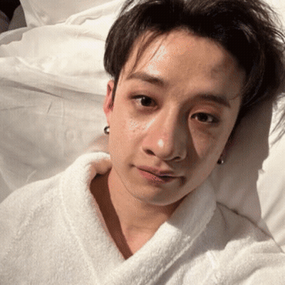 Young Man In White Robe Lying In Bed GIF