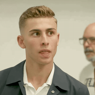 Young Man In White Shirt And Black Jacket With R Badge GIF