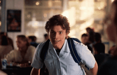 Young Man In White Shirt And Blue Backpack Smiling GIF