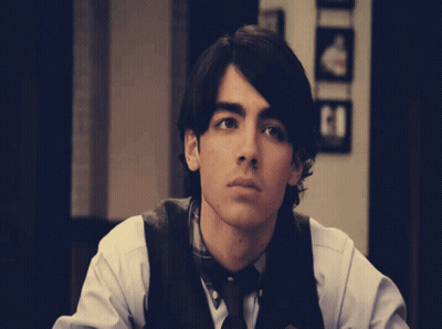 Young Man In White Shirt And Brown Vest GIF