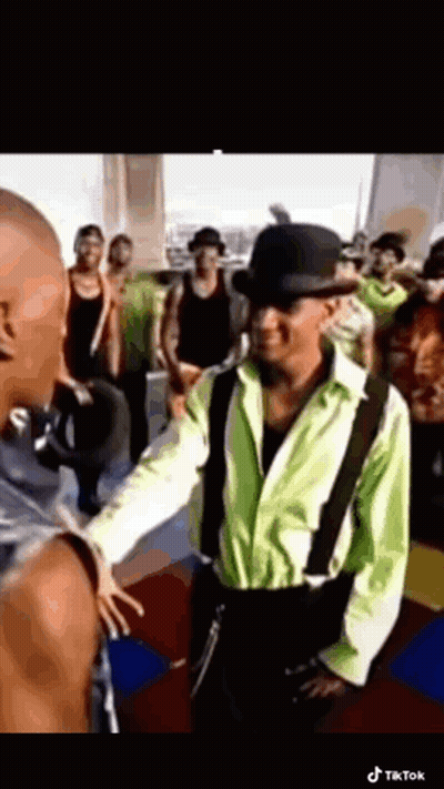 Young Man In White Shirt And Brown Vest Looking At Camera GIF