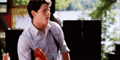 Young Man In White Shirt And Tie Holding Frisbee Talking GIF