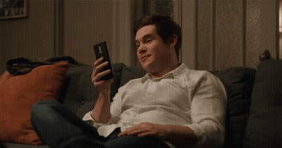 Young Man In White Shirt Holding Cell Phone GIF