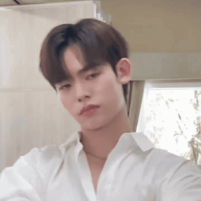 Young Man In White Shirt Looking At Camera GIF