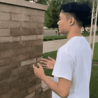 Young Man In White Shirt Looking At Phone GIF