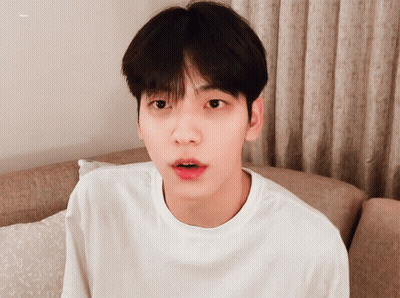 Young Man In White Shirt On Couch Looking At Camera GIF