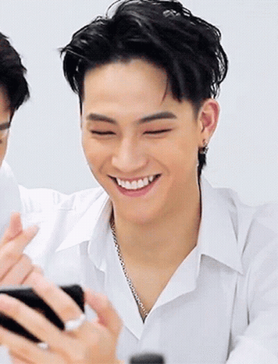 Young Man In White Shirt Smiling Holding Cell Phone GIF