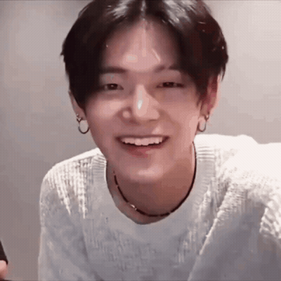 Young Man In White Sweater And Black Necklace Smiling GIF