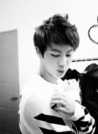Young Man In White Sweater And Striped Shirt GIF
