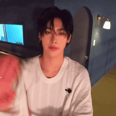 Young Man In White Sweater Standing In Room GIF