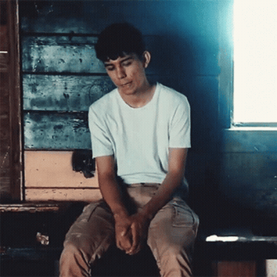 Young Man In White T-Shirt On Bench By Window GIF