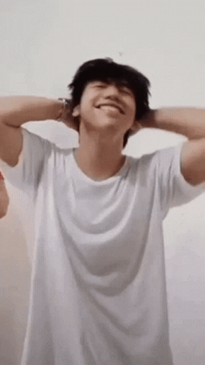 Young Man In White T-Shirt With Hands Behind Head GIF