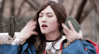 Young Man In Wig And Crown Holding Green Bag GIF