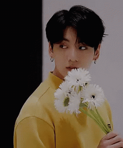 Young Man In Yellow Shirt Holding White Flowers GIF