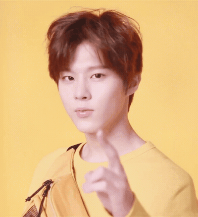 Young Man In Yellow Sweatshirt And Yellow Bag Pointing GIF