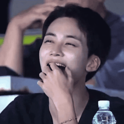 Young Man Laughing With Water Bottle In Stadium GIF