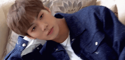 Young Man Laying On Couch In Denim Jacket GIF
