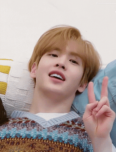 Young Man Laying On Couch Making Peace Sign GIF