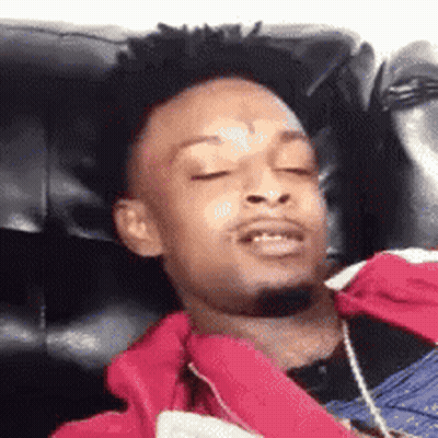 Young Man Laying On Couch With Red Jacket GIF