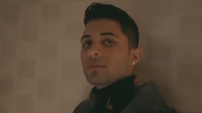 Young Man Leaning Against Wall Smiling GIF