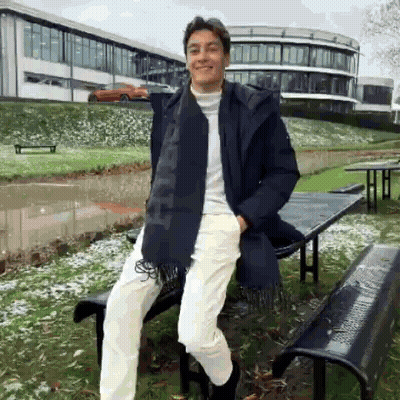 Young Man Leaning On Bench In Front Of Building GIF