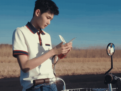 Young Man Looking At Phone Next To Bicycle GIF