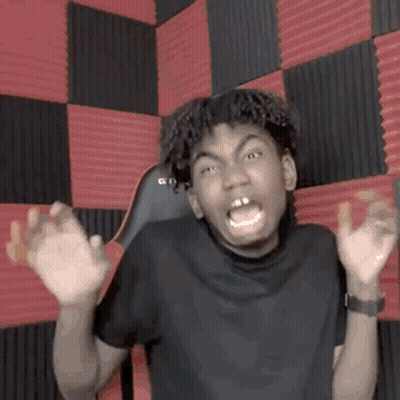 Young Man Making Funny Face At Red And Black Checkered Wall GIF