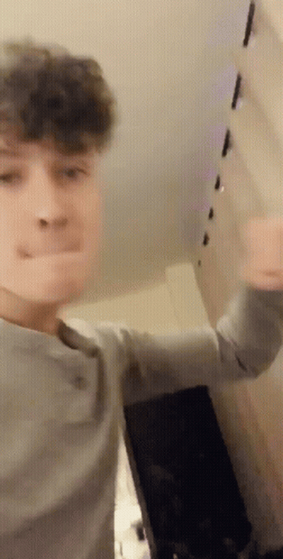 Young Man Making Funny Face In Front Of Wall GIF