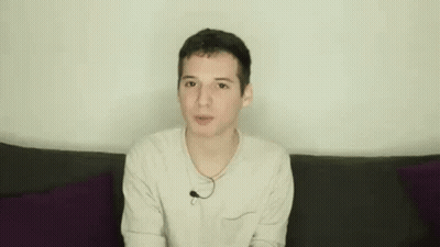 Young Man On Couch Making Funny Face Hands Up GIF