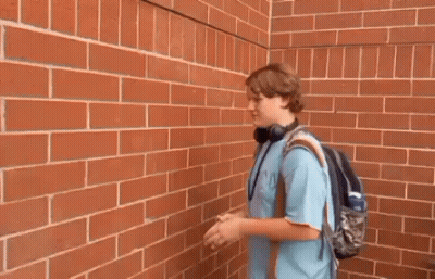 Young Man Outstretched Hands Brick Wall GIF